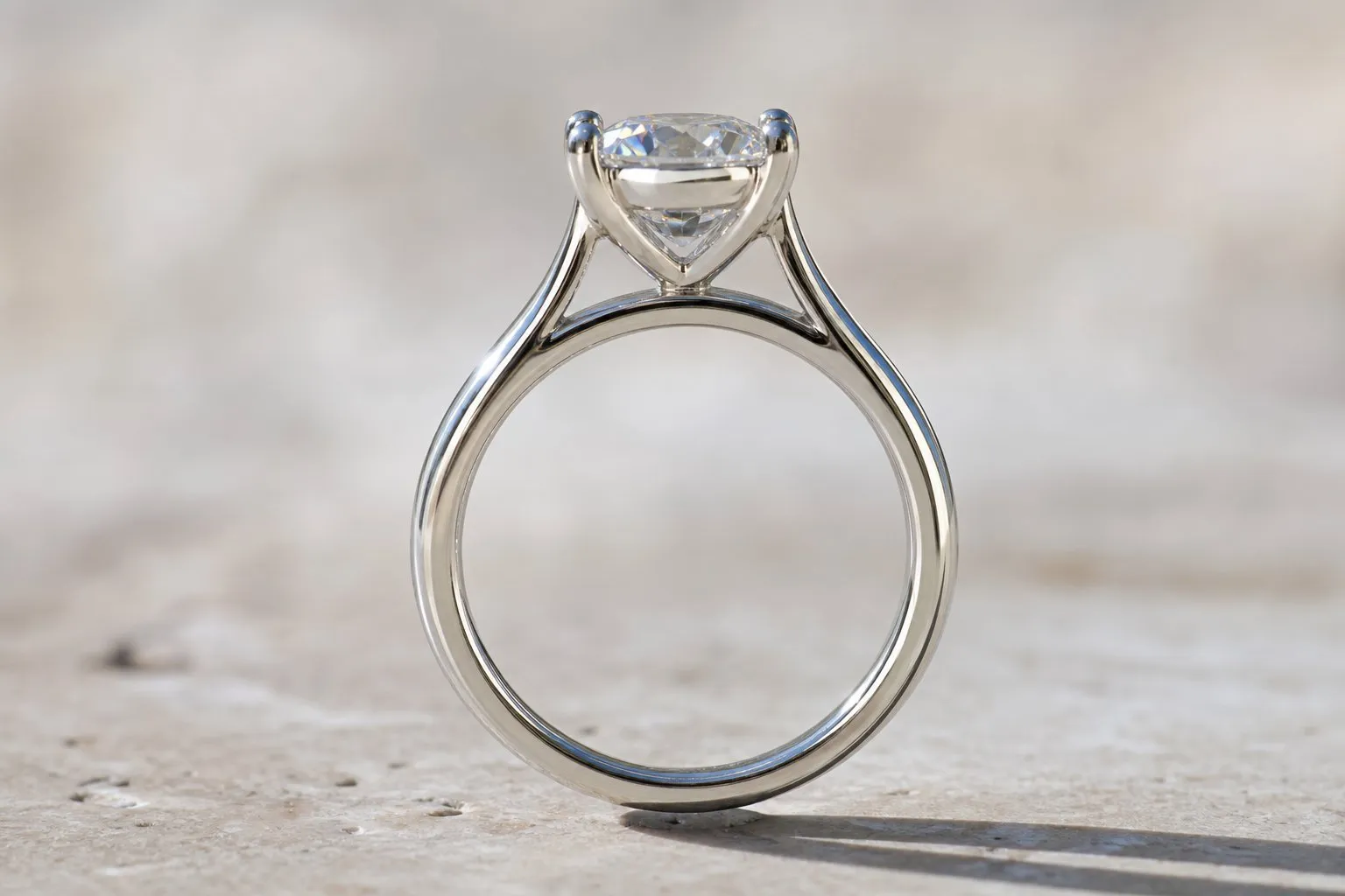 Side view of a white gold cathedral setting, its arches lifting a single diamond above the band