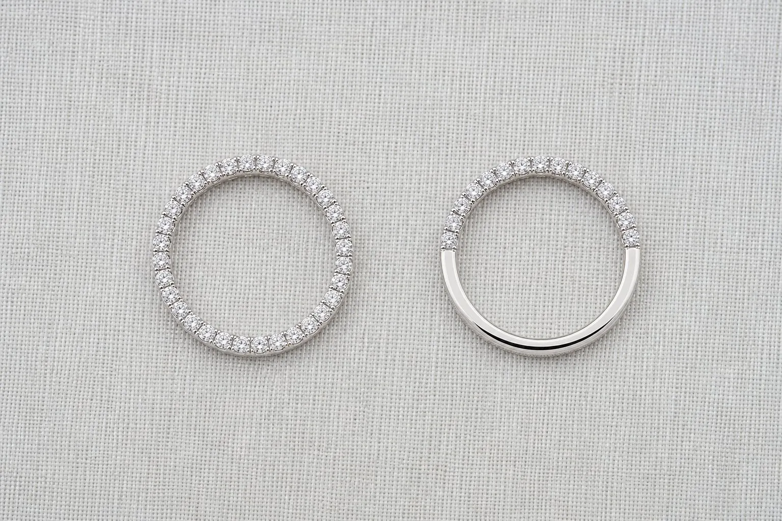 A full eternity band set with stones all the way around, beside a half eternity band whose lower half is plain metal